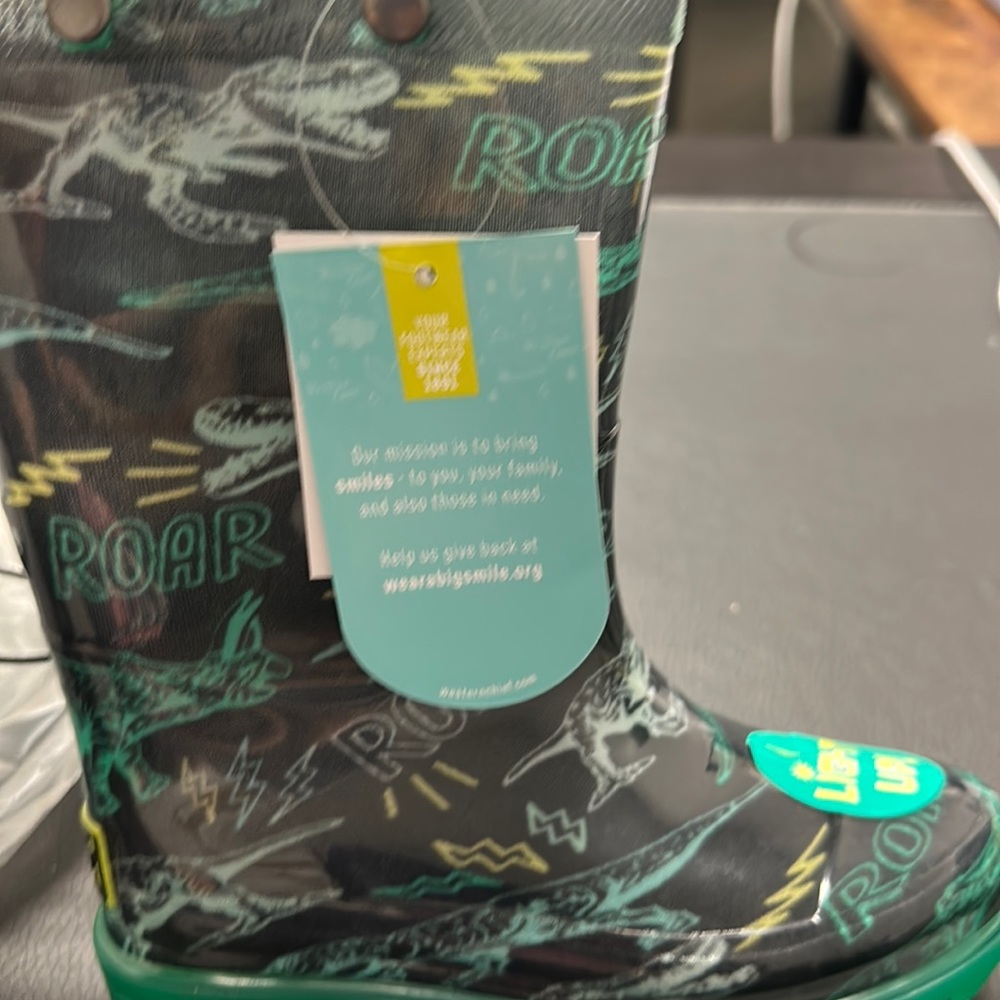 Little boy, dinosaur rain boots that light up